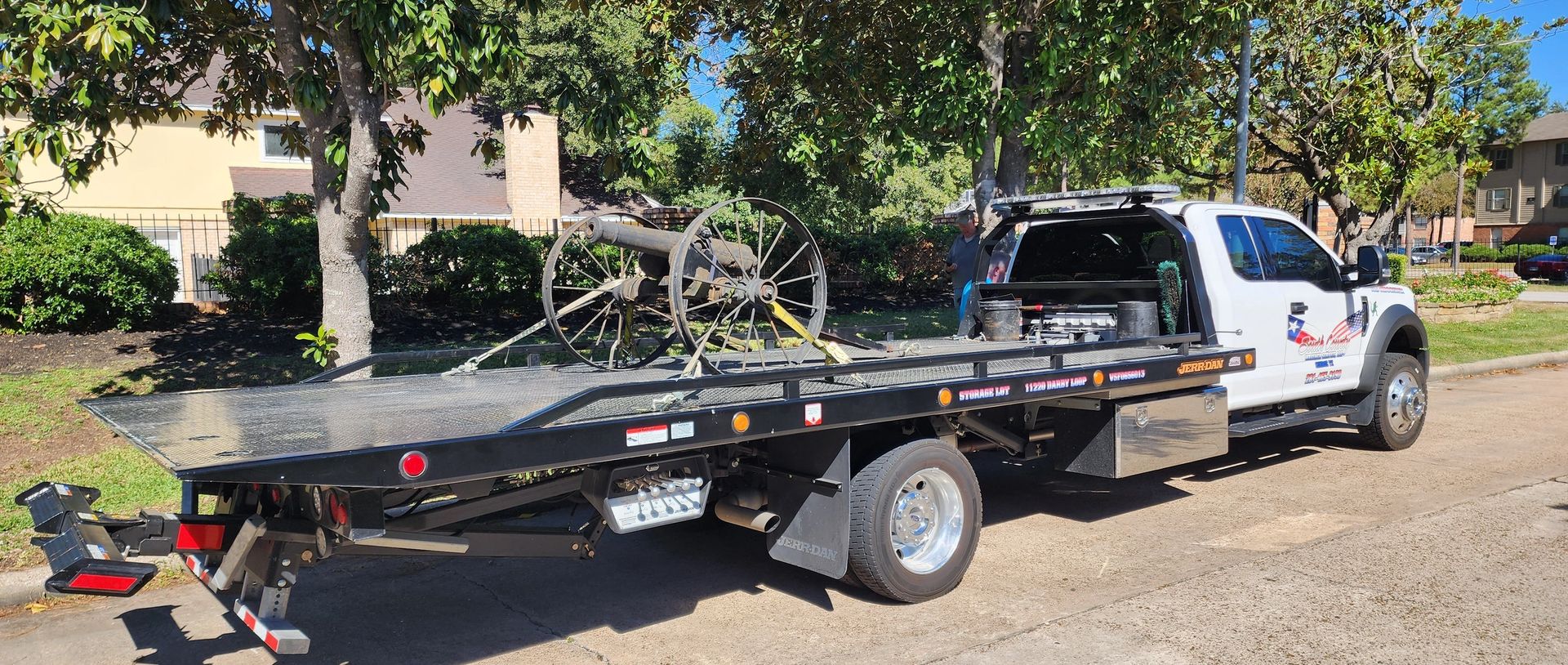 Flatbed truck transporting antique artillery